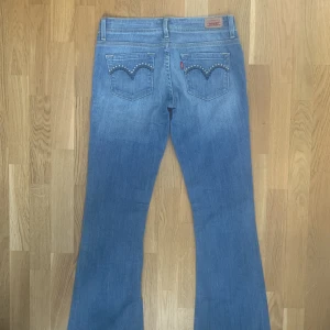 Lågmidjade Jeans - Jättefina lågmidjade jeans från Levis med snygga fickor. Skriv om du undrar något! :)  Mått: 37 cm midja (rakt över) 103 cm ytterlängd 80 cm innerbenslängd
