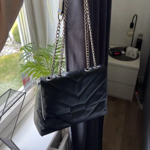 Svart väska - Säljer denna svarta väskan i skinn med kedja. Kedjan kan vara både lång och kort och man får plats med mycket i väskan.