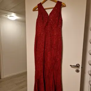 Röd långklänning med röda paljetter. Den är från bubbleroom. Klänningen är aldrig använd så den är som ny. Strl 44