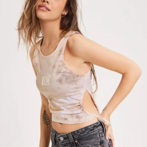 Topp från Calvin Klein Jeans - Helt ny Topp från Calvin Klein Jeans, etikett fortfarande på.  Printad logotyp på bröstet Cut out med drapering på sidan. Ny pris 549 kr 