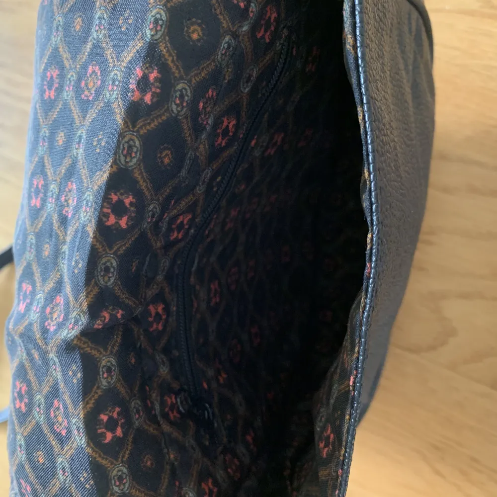 Svart vintage skinnväska med blommig insida. Crossbody bag.  Ett litet fack med dragkedja i väskan.. Väskor.