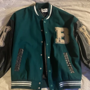 Bones Varsity jacka - Grön och svart baggy jacka med ben längst läderarmarna. 