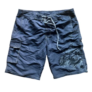 Cargoshorts  - Dom ser blåa ut i bilden men är gråa, skick: 8/10! Går dessutom att använda som badbyxor. Skriv om du har frågor eller vill se fler bilder! 