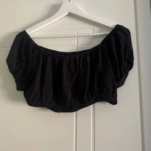Kort off-shoulder topp - Säljer min svarta, korta off-shoulder topp som är perfekt nu till sommaren. Har använt 1 gång och den formar sig till kroppen.  