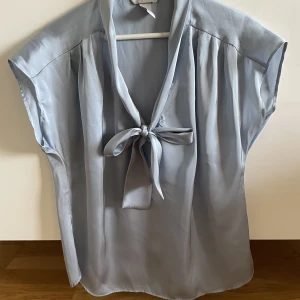 Ny satinerad knytblus i storlek 42 - Ny satinerad knytblus i storlek 42 •Tunn blus med knytband som aldrig  var använd, bara upptvättad 🌸 •Storlek 42 •Pris: 85 kr 🚫Djurfritt och rökfritt hem 📍Kan mötes upp i Mölnlycke 📬Kan skickas mot fraktkostnad (52 kr)