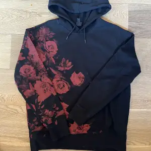 Svart hoodie med röda rosor från H&M i storlek L