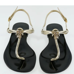 Trendiga sandaler, storlek 37 - Somrig sandal med spänne och reglerbar rem för optimal passform och dekorativa sömmar. Lätt och flexibel. Färg: Svart och guld.  