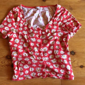 Tröja  - En gullig röd tröja med vita blommor. Den är köpt från monki för många år sedan. Perfekt till sommaren! 