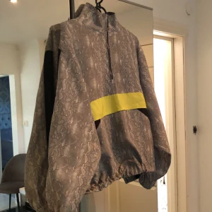 Träningströja - En snygg tröja att dra över vid träning eller löpning utomhus. Tunt material som gör att huden andas. 