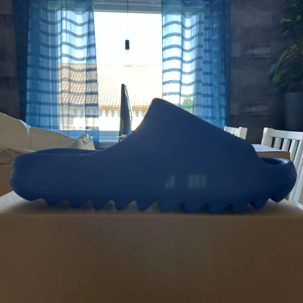 Helt nya blåa yeezy slides. Storlek 43 men passar storlek 42. Köpta på adidas appen. Oanvända. Frågor? Skriv till mig :). Skor.