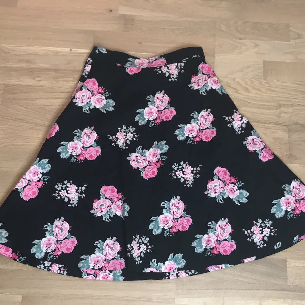 Fin svart lång kjol med rosa rosor 🌷Inte golv lång men längre än knäna. 💗Från Lindex och storlek 36. (Tröjan i bilden säljs också, 60kr). Kjolar.