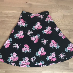 Blommig svart långskjol💗🖤 - Fin svart lång kjol med rosa rosor 🌷Inte golv lång men längre än knäna. 💗Från Lindex och storlek 36. (Tröjan i bilden säljs också, 60kr)