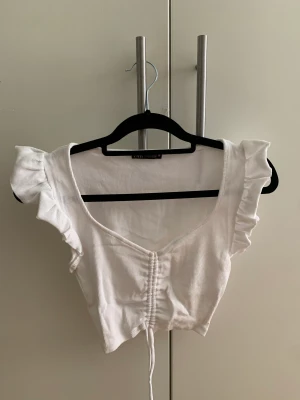 Topp - Somrig ribbad topp från Zara. Går att göra kortare och längre vid naveln. Volanger på axlarna