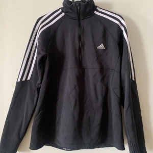 Half zip adidas fleece - Half zip adidas running fleece i svart med vita ränder.