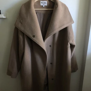 Kappa med hög krage - Kappa från NA-KD med hög krage i beige. Nyskick, helt oanvänd. 