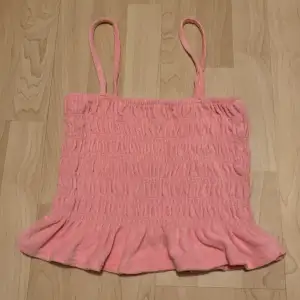 En rosa topp/linne perfekt till sommaren. I ett fint frotté material. Säljer för den inte har kommit till användning. Den är i superbra skick då den har blivit använd 1-2 gånger.