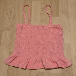 Sommartopp  - En rosa topp/linne perfekt till sommaren. I ett fint frotté material. Säljer för den inte har kommit till användning. Den är i superbra skick då den har blivit använd 1-2 gånger.