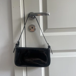 Svart väska  - Svart liten handväska i glansigt material😊