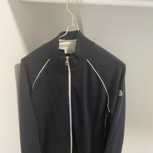 Moncler Jumper - Moncler jumper/sweater med zipper mörkblå med vita detaljer, använd fåtal gånger pågrund av för stor för mig