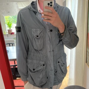 Stone Island jacka - Säljer en Stone Island jacka. Jackan är en typ av vindjacka och funkar bra för tidig höst, vår och sommarkvällar. Skicket är som nytt och den har aldrig blivit använd enbart testad. 9.5/10. Färgen är en metallaktig ljusblå färg. Nypriset för jackan=8600kr