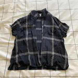 Säljer en svart-rutig kortärmad skjorta i storlek M