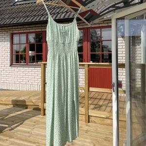 Hollister sommarklänning med liten slits  - Superfin grön/vit sommarklänning med blommigt motiv💐Strl S och knappt använd! 