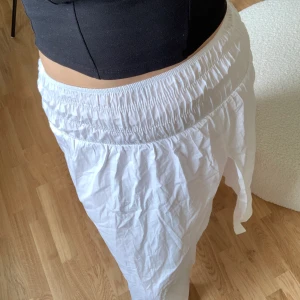Midikjol i vitt  - Luftig kjol med slits i ena sidan med resår i midjan. Aldrig använd med lappen kvar