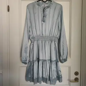 Isblå klänning i satin från Nakd, använd vid ett tillfälle så superfint skick 