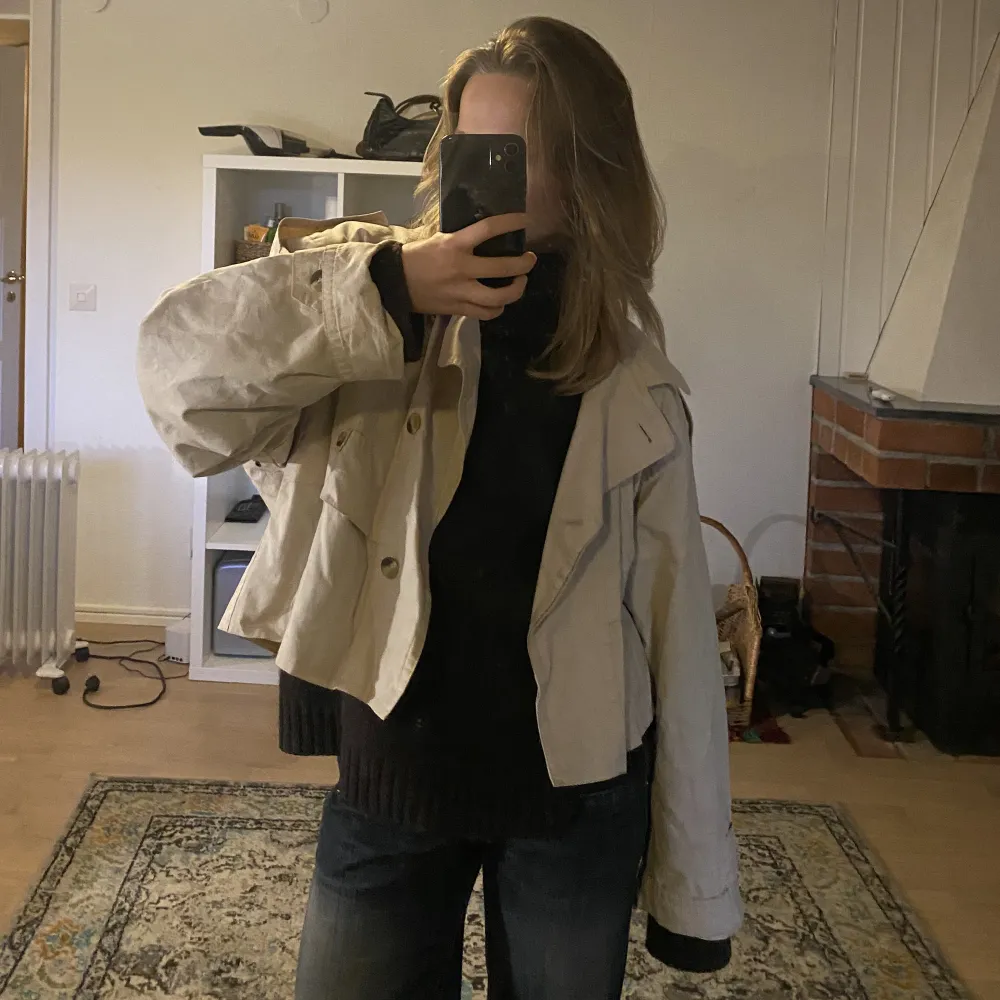 Supersnygg & trendig trenchcoat i croppad/kort modell. Beige färg. Fin till hösten💕köpt i Paris, står inget märke eller storlek men en S/M uppskattningsvis!. Jackor.