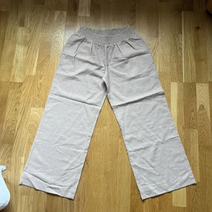 Linnebyxor  - Ett par fina och oanvända linnebyxor i beige färg. Inga snören utan ett elastiskt band 