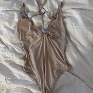 Rosa nude body med snörning - Rosa nude body med snörning Stl S  Från Rebecca Stella  Stretch 