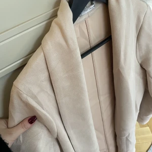 lite längre tunn kappa - en ljus puderrosa kappa, väldigt tunn mocka. ungefär knälång på mig som är 160. Legat nerpackad därav lite skrynklig, behöver bli av med snabbt, därav priset.  Använd fåtal gånger.  Storlek S, från Zara. 