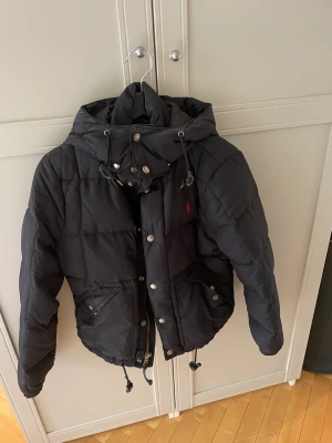 Jacka Ralph Lauren - En kort dunjacka från Ralph Lauren. storlek S. Lite smink på kragen men lätt att få bort med sminkservett/ liknande.   Säljer billigt, behöver bli av med asap. 