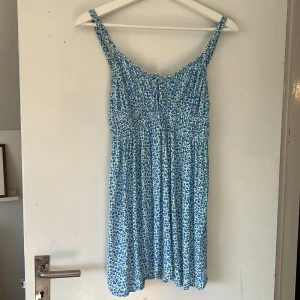 Klänning - Blommig kort klänning. I nyskick, använd några gånger.