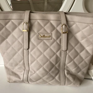 Stor handväska - En stor handväska där man får plats med en dator mm. Den är använd en del så har några små skavanker men är fortfarande supersnygg. Har en grå färg med lite beiget. Kan skickas omgående, pris kan diskuteras.