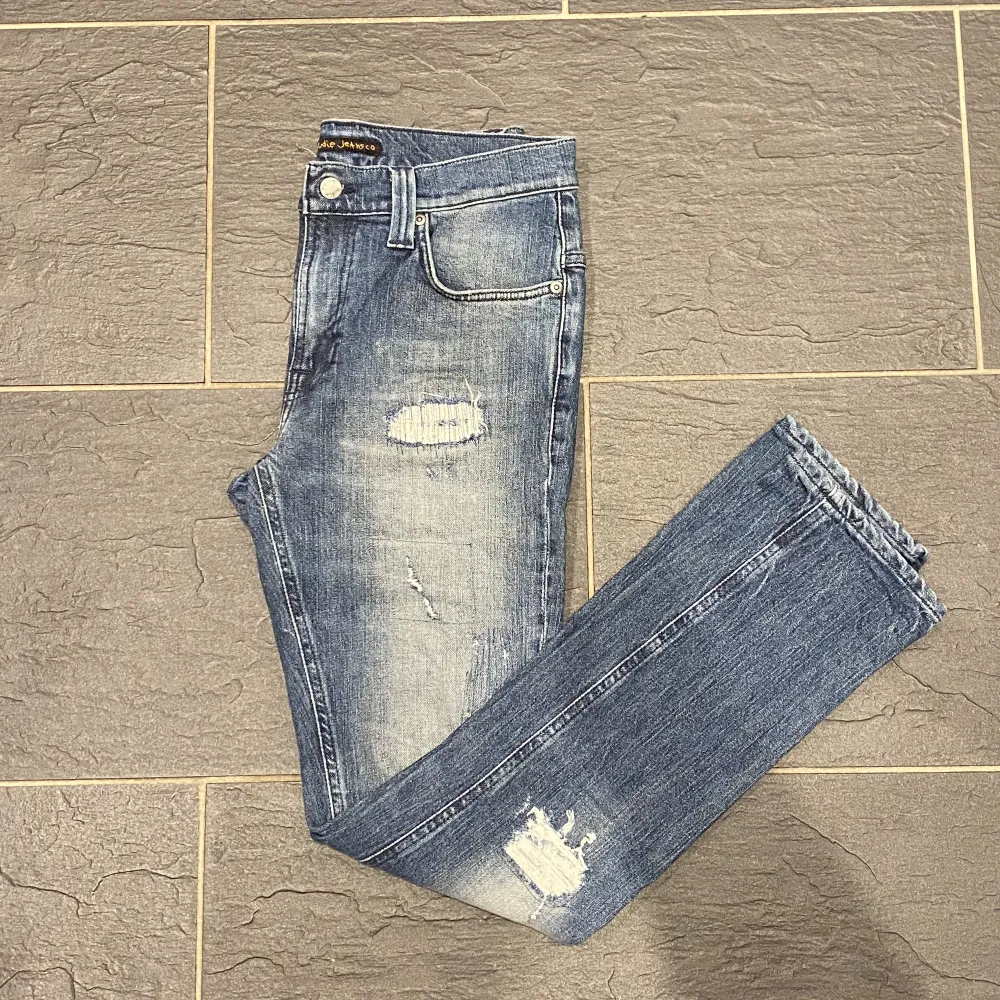 Ett par riktigt fräscha nudie jeans i perfekt skick.   Storlek: 30/32.   Modell: Tape ted.   Passform: Slim fit.  Nypris:1400.   Vårat pris: 649. . Jeans & Byxor.