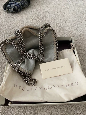 Stella McCartney tiny - Säljer denna fina Stella McCartney väskan i modellen tiny!  Kedjan är lite rostig men annnars är den i fint skick! Skulle säga att den är nästan lite silvrig❤️ Skulle även kunna tänka mig att byta mot en svart i samma modell
