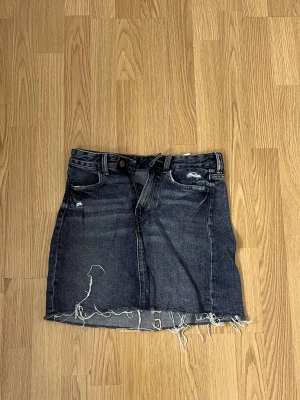 Jeanskjol  - Jeanskjol i mörkblå/grått, använd 1 gång. Storlek 34.