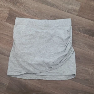 Tight kjol - Grå tight/stretchig kjol med överlapp framtill. Stilig!