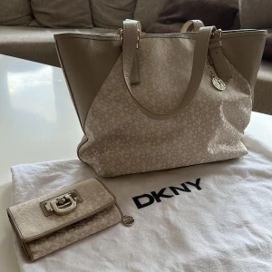 Dkny väska med plånbok  - Säljer min fina Dkny väska tillsammans med plånbok. Plånboken har lite fläckar på, kan skicka fler bilder vid instresse. Kvitto finns. Man kan köpa de separat om du är intresserad så säg bara till så löser jag det. 