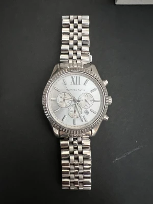 Michael kors klocka i rostfritt stål - Äkta Michael kors klocka i rostfritt blankt stål. Fick den i present 2019 så har inget kvitto. Väldigt fint skick. Säljes med box och extra länk. Funkar både för Herr och Dam. 