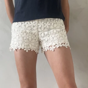 Vita blommönstrade shorts - Vita korta och gulliga vita shorts från collierer. Blommönstrade ”spets” shorts. Vet ej storlek men passar mig som har xs i storlek, står dock en nolla men vet inte vad det betyder. Köparen står för frakt!