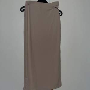 En lång beige kjol med slits 