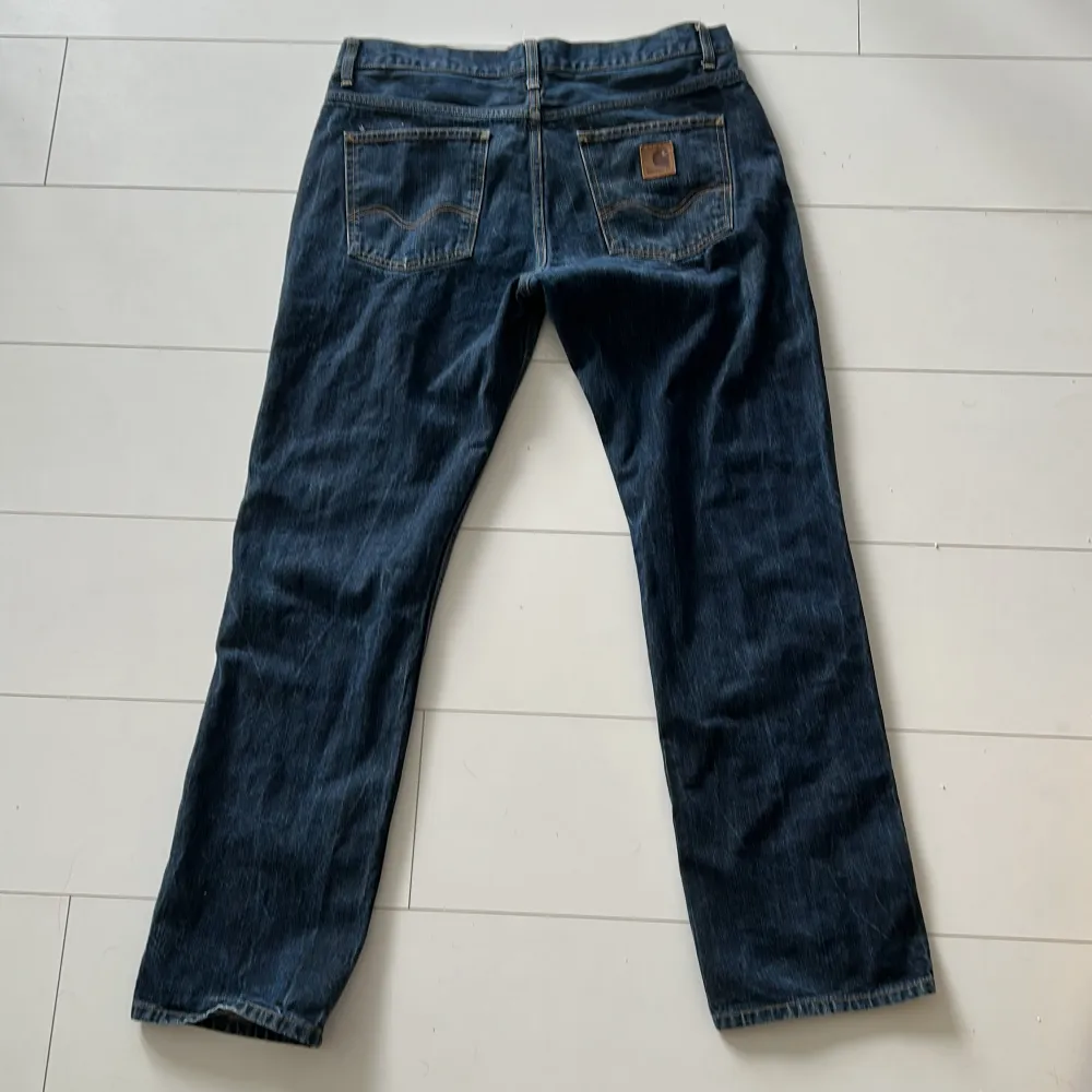 Carhartt WIP Jeans i mörk blå färg. Bra skick förutom ett litet hål på höger sida av byxorna.  Storlek: 34/32 . Jeans & Byxor.