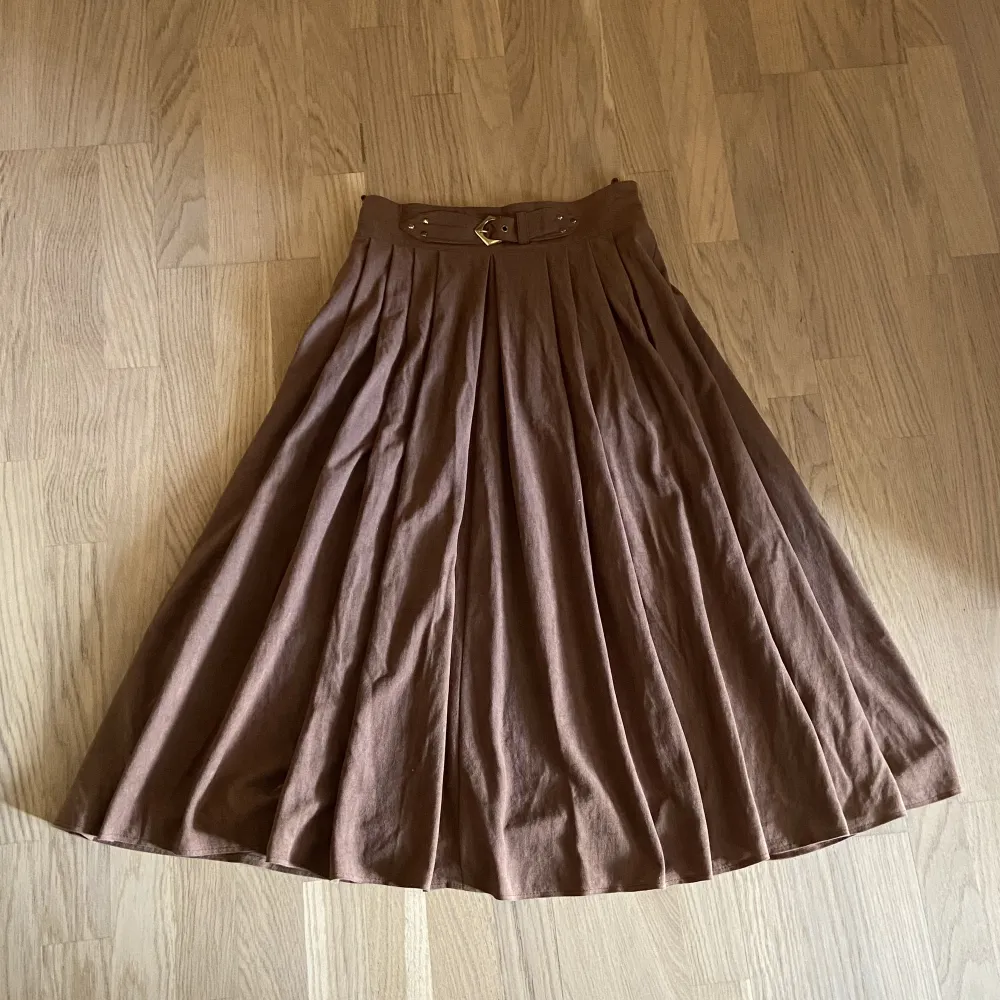 Vacker brun långkjol med kort skärp där framme där man kan anpassa storlek (finns två storlekar). Materialet är mjukt och lite tjockare och därför värmen kjolen bra. Kjolar.