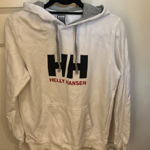 Helly Hansen hoodie - Vit Helly Hansen hoodie i storlek herr S. Insidan av luvan är grå.