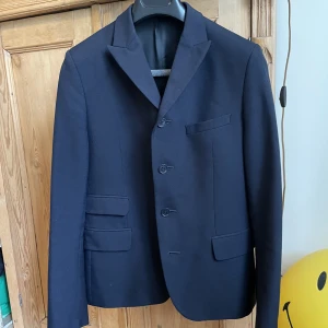 Kavaj Velour By Nostalgi - En gubbsnygg marinblå kavaj från Göteborgsbaserade Velour by Nostalgi. Fick den av en god vän i present när jag fyllde 22, nu är jag 26 och mycket bitigare. Står storlek 48, skulle påstå att det är 46 och att grabbarna på Velour är ätstörda. 55 ull 45 pol