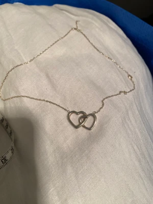 Silverhalsband med hjärtan - Äkta silverhalsband med 2 hjärtan. Verkligen jättefint. Kedjan är ca 45 cm lång..
