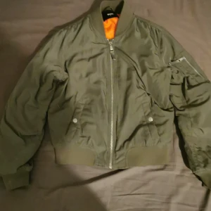 Jacka  - En fräsch bomber-jacka med en cool orange innefärg, väldigt bra skick. 