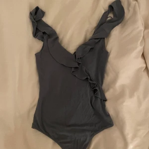 Fin body - En body i en gråblå färg med volanger 🫶 sitter så fint på! 